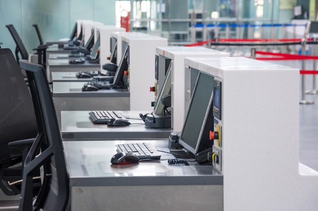 Fila de mostradores de facturación vacíos con monitores de computadora en el aeropuerto.