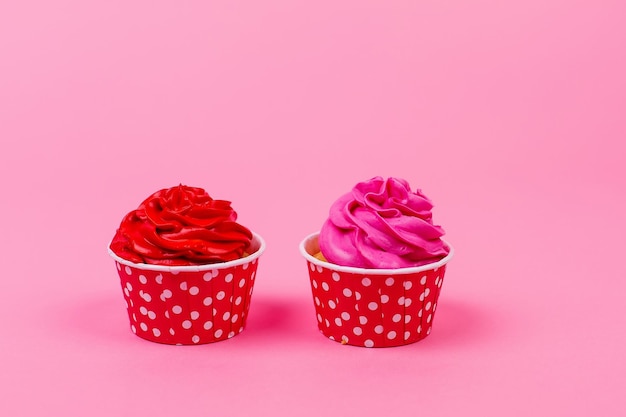 Una fila de pastelitos de colores sobre un fondo rosa