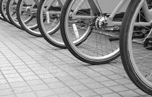 Fila de ruedas de bicicleta en la acera del centro para un concepto ecológico