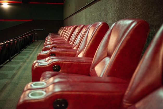 Una fila de sillas de cuero rojo en un cine.