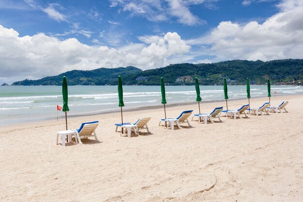 Fila de sombrillas y sillas en la playa en un día soleado