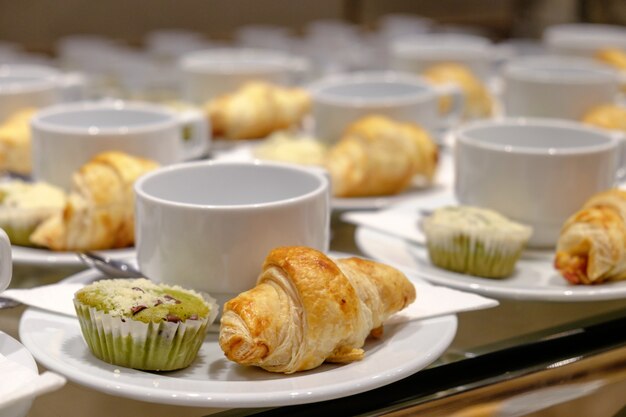 Fila de la taza de café y la magdalena, Croissant para el seminario o reunión de descanso