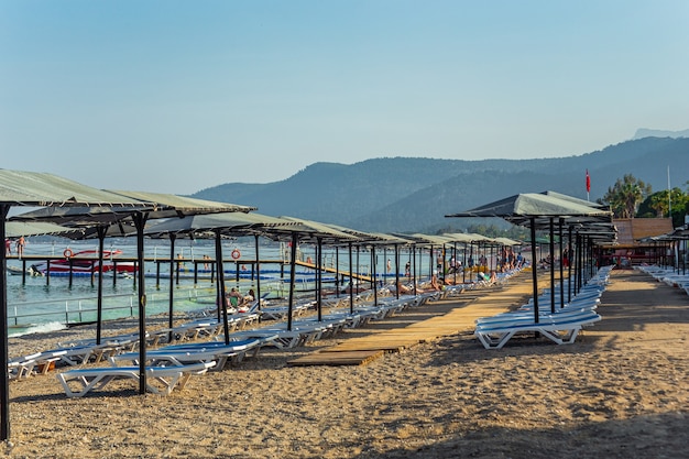 Fila de tumbonas vacías en la playa en Kemer Antalya