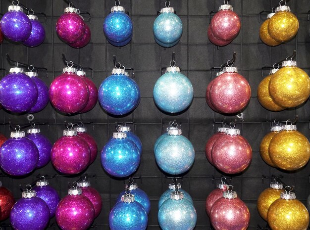 Foto filas de bolas de natal penduradas por cor para venda