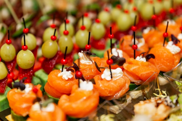 Filas de deliciosos canapés en la mesa festiva. Catering para reuniones de empresa, eventos y celebraciones.