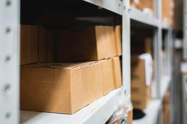 Foto filas de estantes con cajas de cartón en un almacén moderno, cajas marrones de primer plano en estanterías metálicas