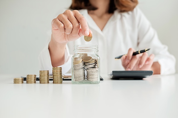 Filas de las monedas para el concepto de las finanzas y de las actividades bancarias con el hombre y la mujer de negocios. Una metáfora de la consultoría financiera internacional.