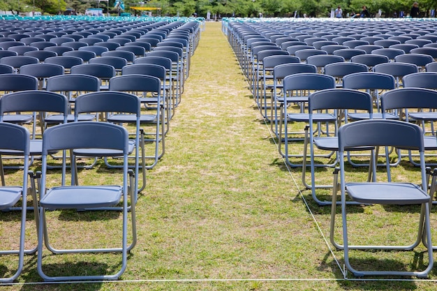 Filas de sillas grises en la ceremonia del césped en verano