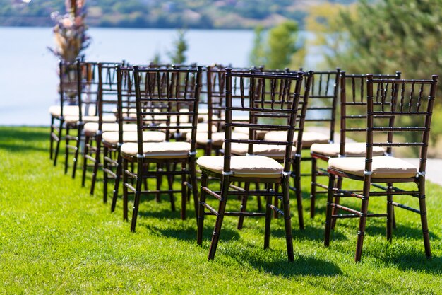 Filas de sillas para invitados a una ceremonia de boda al aire libre.