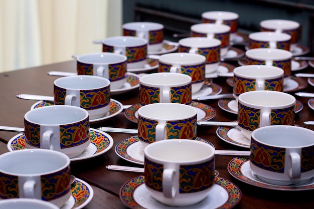 Filas de taza y platillo de colores puros con cucharadita