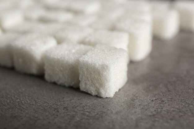 Filas de terrones de azúcar sobre fondo gris