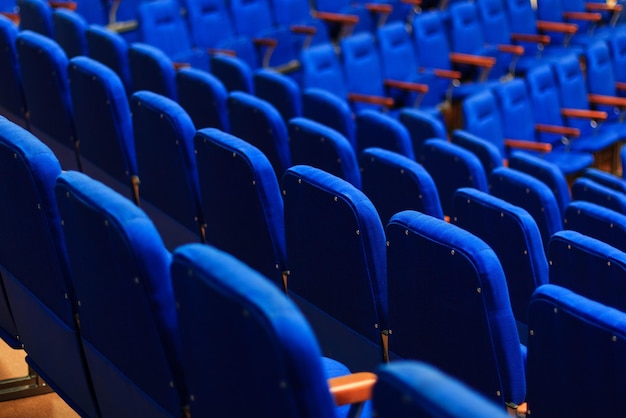 Filas de textura de sillones azules de terciopelo suave en el auditorio del teatro