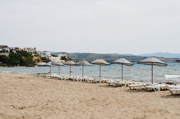 Filas de tumbonas y sombrillas vacías en la playa. Playa de camellos en Turquía.