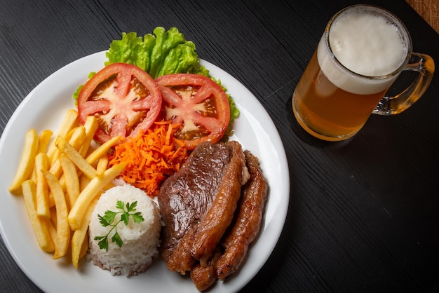 Filé com fritas servido com arroz e alface salada de tomate e cenoura