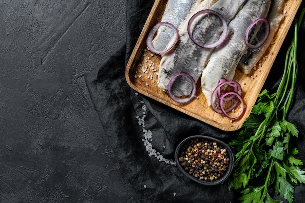 Filé de arenque salgado com salsa e cebola vermelha.