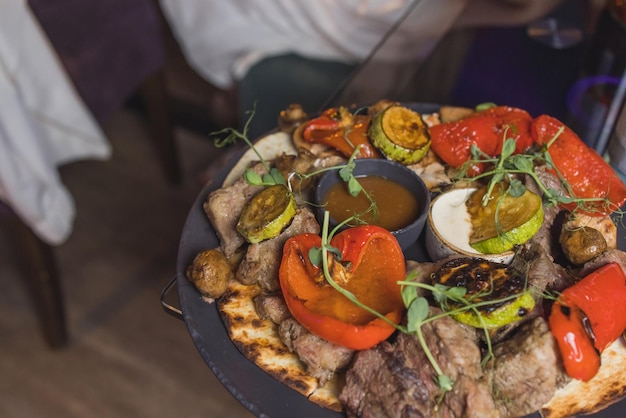 Foto filé de bife grelhado e molho de pimenta na tábua em fundo escuro de madeira