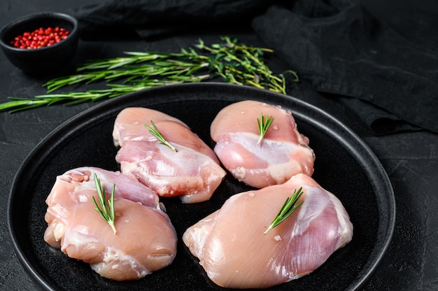 Filé de coxa de frango cru sem pele. Carne de aves de capoeira. Parede preta. Vista do topo