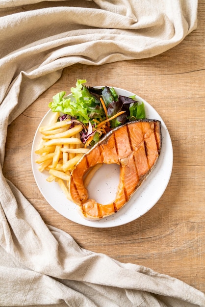 filé de filé de salmão grelhado com legumes e batatas fritas no prato