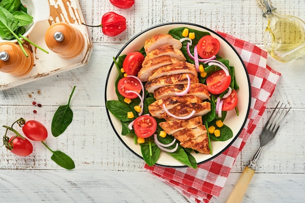 Filé de frango com salada de espinafre, tomate cereja, centáurea e cebola