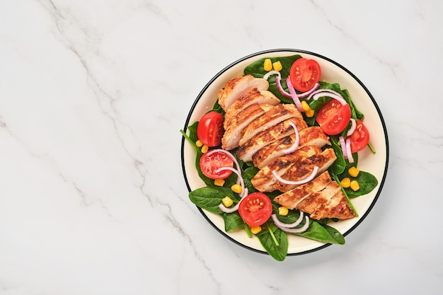 Filé de frango com salada de espinafre, tomate cereja, centáurea e cebola