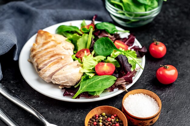 Filé de frango com salada e espinafre comida saudável na mesa de pedra