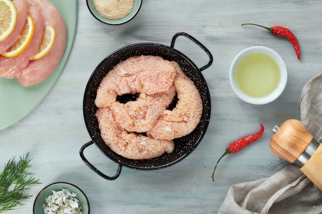 Filé de frango cru. carne com farinha de rosca, ervas, limão e óleo de cozinha