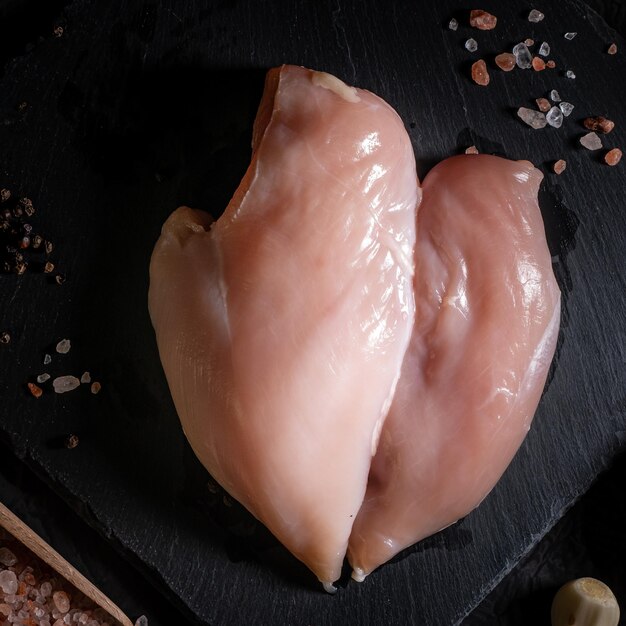 Foto filé de frango cru em fundo de pedra com espaço de cópia para o seu texto