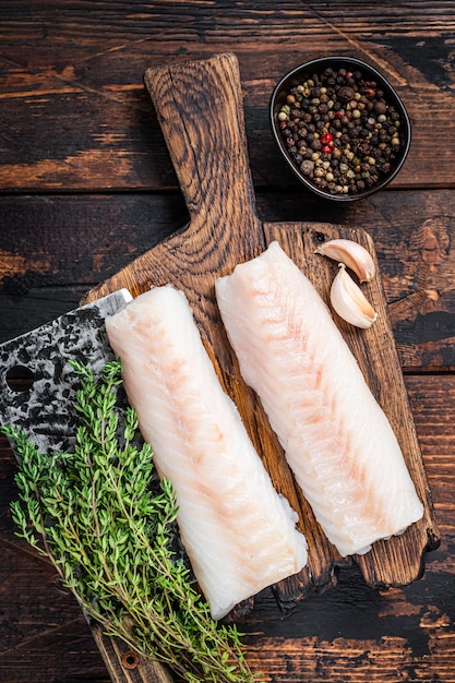 Filé de lombo de bacalhau cru na tábua de madeira com cutelo