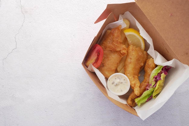 Filé de peixe com chips de limão e purê de batata em caixa para levar na mesa