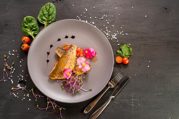 Filé de peixe com legumes em fundo de madeira