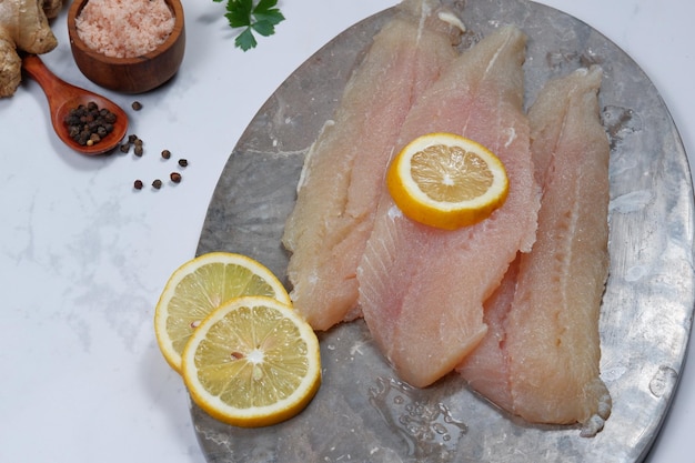 Filé de peixe fresco Pangasius dory com ingrediente no fundo branco