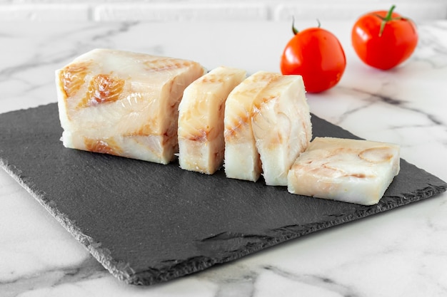 Filé de peixe pangasius congelado na placa de pedra pronto para cozinhar.