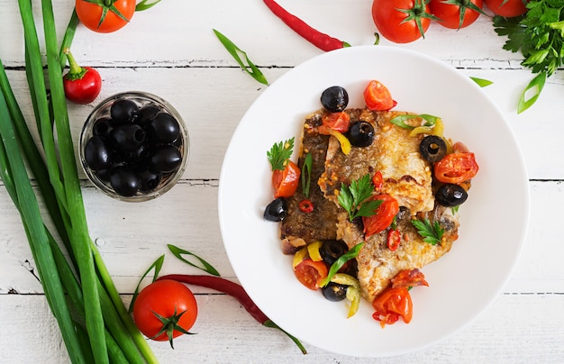 Filé de pescada frito com tomate e azeitonas em estilo mediterrâneo. Vista do topo