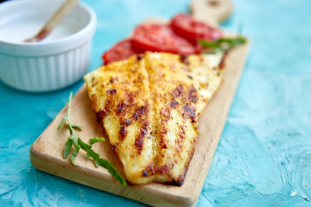 Filé de pique grelhado com tomates na placa de madeira