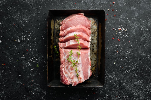 Filé de porco cru com especiarias sobre fundo de pedra preta Carne Vista superior Estilo rústico