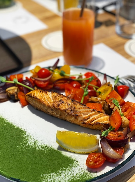 Foto filé de salmão assado com legumes enfeite em um prato. refeição saudável