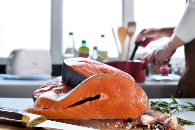 Filé de salmão cru fresco com ingredientes em uma tábua de cortar na cozinha