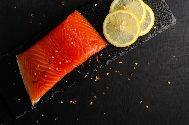 Filé de salmão e rodelas de limão no preto