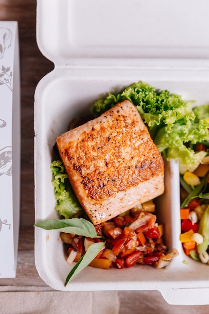 Filé de salmão grelhado com tomate e salada de broto de feijão.