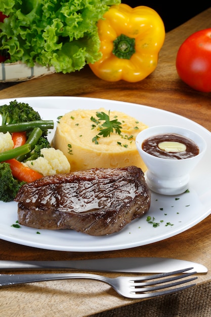 Filé grelhado com purê de batata, legumes no vapor e molho barbecue