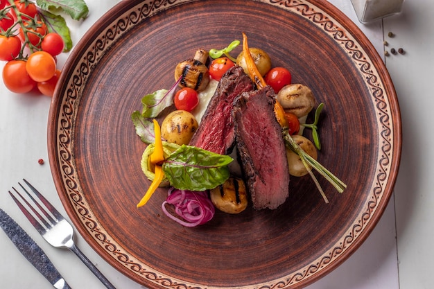 Filé mignon servido com legumes grelhados e cogumelos prato de restaurante Vista superior Closeup