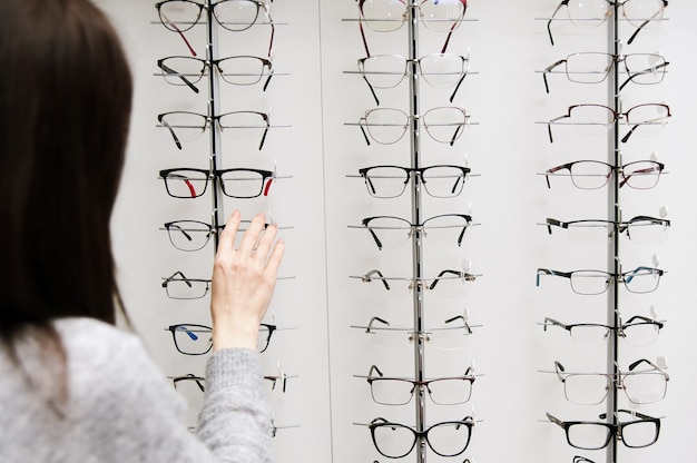 Fileira de óculos em um oculista. loja de óculos. fique com óculos na loja de ótica.