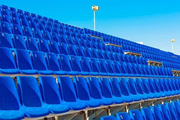 Fileiras de estádio vazio de plástico de cor azul no terraço.