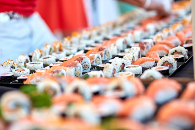 Fileiras de sushi saboroso variado com peixe colocado em tenda em buffet asiático