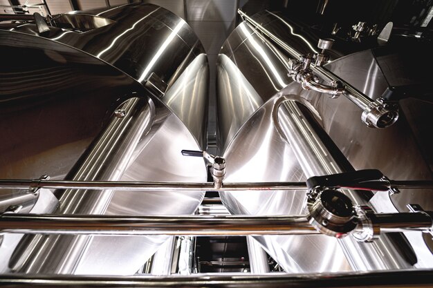 Fileiras de tanques de aço para fermentação e maturação de cerveja em uma cervejaria artesanal