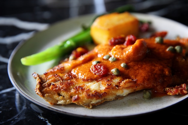 Filés de robalo com molho de tomate e especiarias