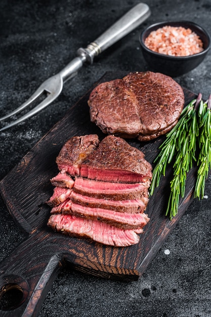 Filet Mignon Filet Gegrillte und in Scheiben geschnittene Rindersteaks. Schwarzer Hintergrund. Ansicht von oben.