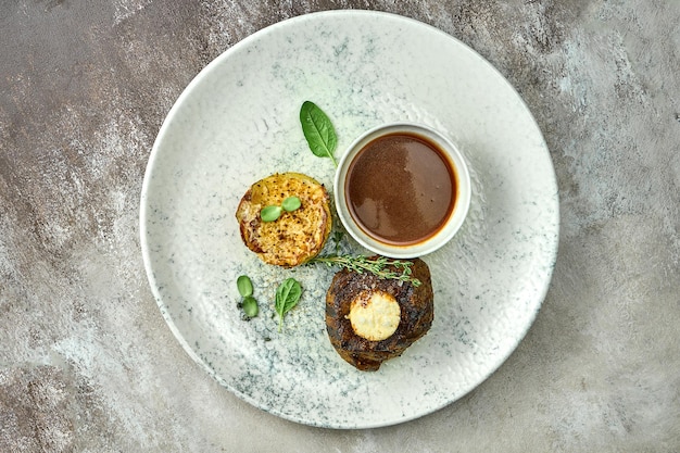 Filet mignon con puré de patatas y salsa en un plato. Primer plano, enfoque selectivo.