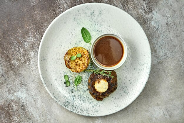 Filet-Mignon-Steak mit Kartoffelpüree und Sauce in einem Teller. Nahaufnahme, selektiver Fokus.