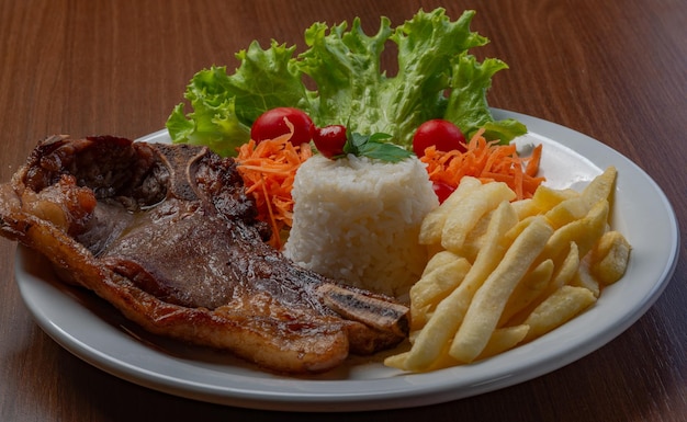 Filet mit Pommes, serviert mit Reis und Kopfsalat Tomaten-Karotten-Salat